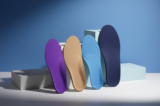 CustomTread custom orthotic insoles next to work boots showing the fit and arch support structure for occupational footwear
