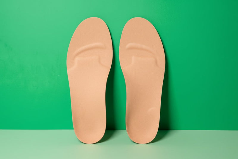 CustomTread orthotic insoles displayed on white surface with soft shadows, product photography